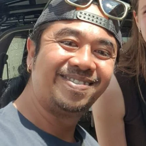Alit, Tirta Bali English-speaking driver, with a guest by the tour car