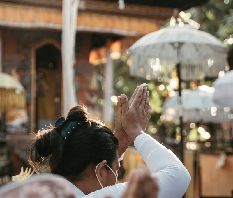 Woman in ceremonial dress praying at a temple
