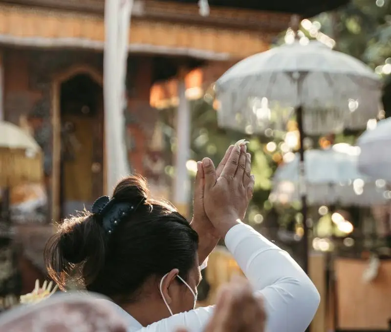 Woman in ceremonial dress praying at a temple