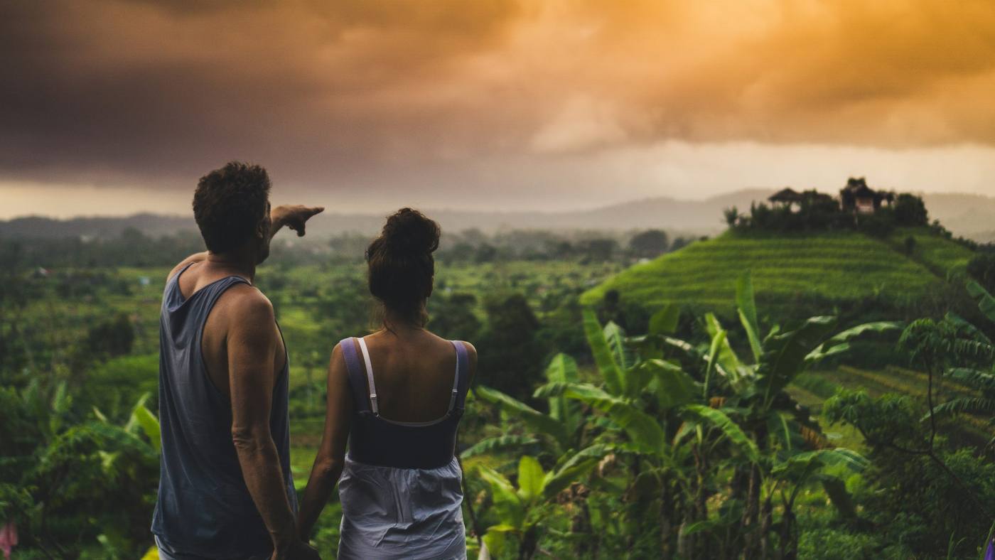 Guest walking through quiet rice fields with a private Tirta Bali guide