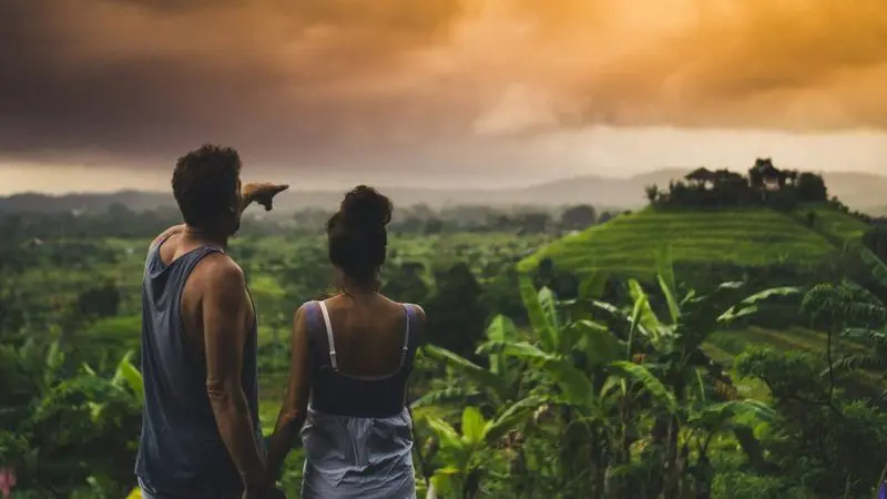 Guest walking through quiet rice fields with a private Tirta Bali driver